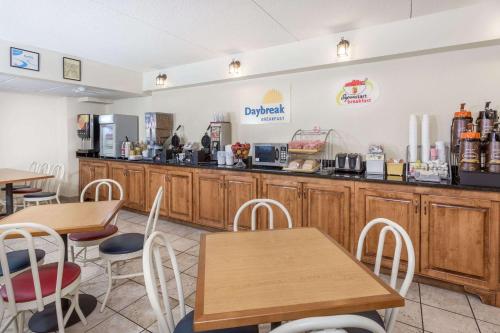 Super 8 by Wyndham Valdosta Mall في فلدوستا: مطعم للوجبات السريعة طاولات وكراسي خشبية