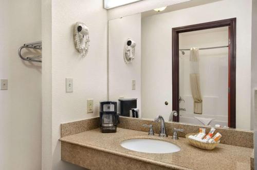 a bathroom with a sink and a large mirror at Howard Johnson by Wyndham Lubbock TX in Lubbock