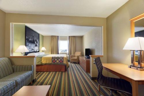 a hotel room with a bed and a couch at Super 8 by Wyndham Lees Summit in Lees Summit