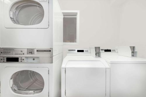 two washing machines and a washer and dryer at Super 8 by Wyndham Midwest City OK in Midwest City
