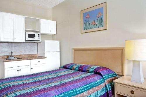 a bedroom with a bed and a microwave at Knights Inn Hallandale in Hollywood