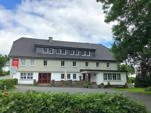 ein großes weißes Haus mit einer roten Tür in der Unterkunft Comfortable Holiday Home in Neuastenberg in Winterberg