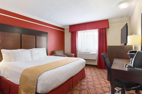 a hotel room with a large bed and a large window at Travelodge by Wyndham Meadow Lake in Meadow Lake