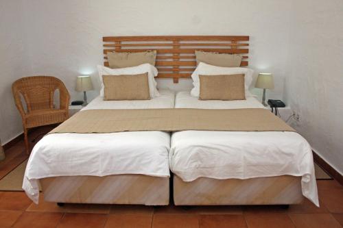 a bedroom with a large bed with white sheets and pillows at Hotel Rural da Ameira in Montemor-o-Novo
