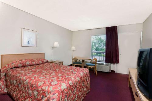 a hotel room with a bed and a television at Knights Inn - Fredericksburg in Fredericksburg