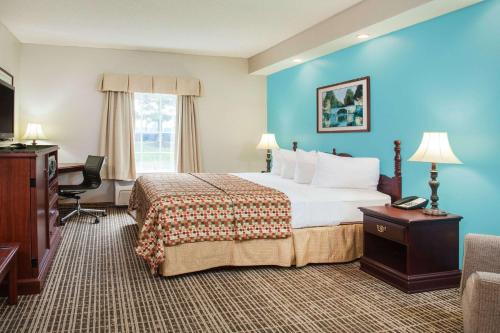 um quarto de hotel com uma cama grande e uma televisão em Howard Johnson by Wyndham Jackson em Jackson