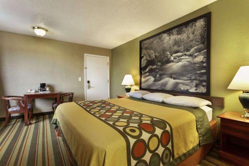 リッジクレストにあるSuper 8 by Wyndham Ridgecrestのベッドとデスクが備わるホテルルームです。
