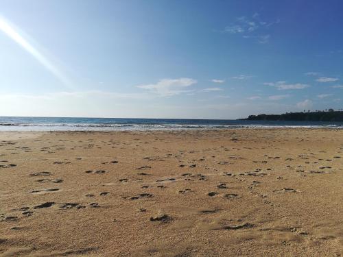 a beach with footprints in the sand and the ocean at Relax Beach House in Tangalle
