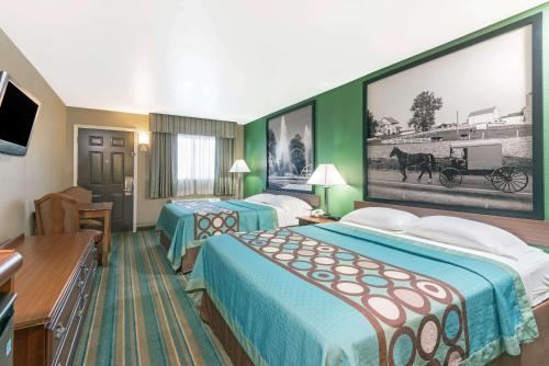 Habitación de hotel con 2 camas y una gran foto en la pared. en Super 8 by Wyndham Greencastle en Greencastle