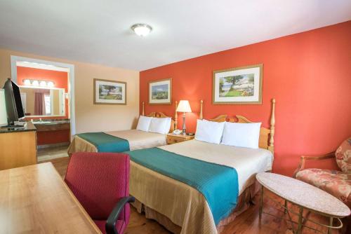 two beds in a hotel room with red walls at The Hillside Hotel in Knoxville