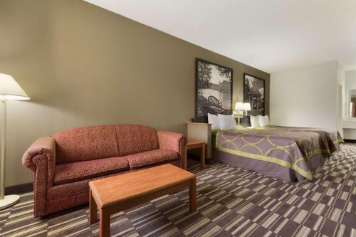 a hotel room with a couch and a bed at Super 8 by Wyndham Chatsworth/Dalton in Chatsworth