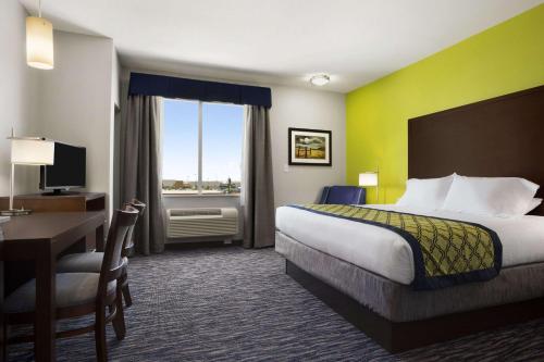 a hotel room with a bed and a desk and a computer at Hawthorn Suites by Wyndham San Angelo in San Angelo