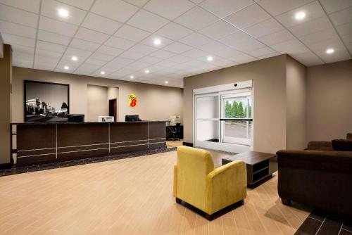 a waiting room with a yellow chair and a couch at Super 8 by Wyndham Hershey Chocolate Avenue in Hershey