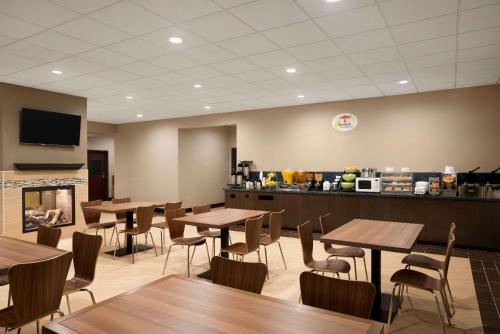 a restaurant with wooden tables and chairs and a counter at Super 8 by Wyndham Hershey Chocolate Avenue in Hershey
