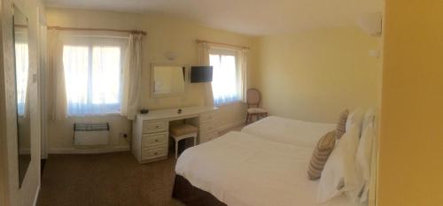 una camera con letto, cassettiera e specchio di Beau Rivage a St Brelade