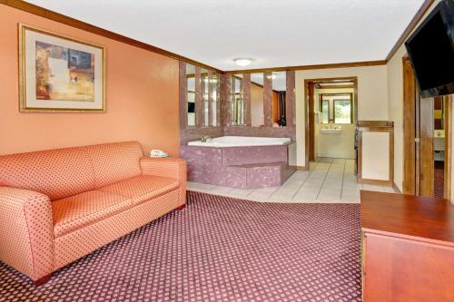 a living room with a couch and a bath tub at Travelodge by Wyndham Sellersburg in Sellersburg