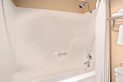 a bathroom with a white tub and a shower at Travelodge by Wyndham Beckley in Beckley