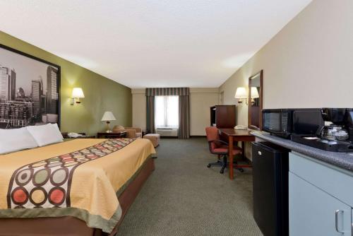 Habitación de hotel con cama, escritorio y TV. en Super 8 by Wyndham Huntersville/Charlotte Area, en Huntersville