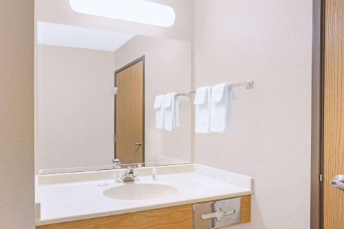 bagno con lavandino bianco e specchio di Super 8 by Wyndham Davenport a Davenport