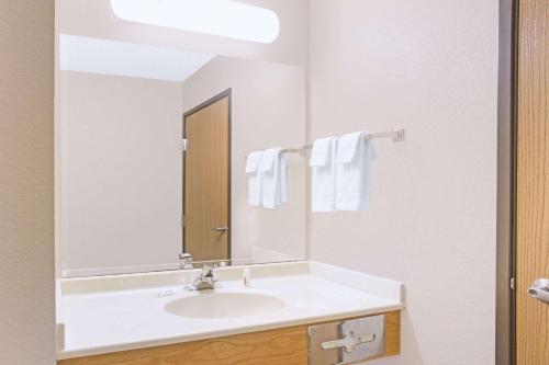 a bathroom with a white sink and a mirror at Super 8 by Wyndham Davenport in Davenport