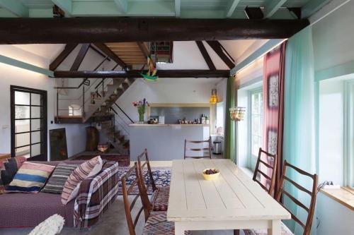 a living room with a table and a couch at Unique place on the river Waal in Heerewaarden