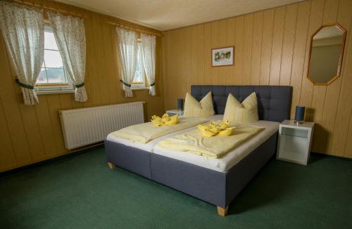 a bedroom with a large bed with yellow flowers on it at Pension Immergrün in Kurort Jonsdorf