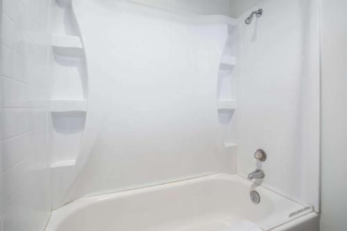 a bathroom with a white tub and a sink at Knights Inn Boardman in Boardman