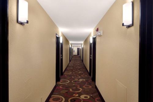 a hallway of a hotel with a long corridor at Super 8 by Wyndham Joplin in Joplin