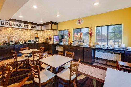 a restaurant with tables and chairs and a breakfast bar at Super 8 by Wyndham Akron S/Green/Uniontown OH in Uniontown