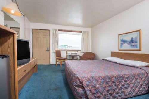 BoardmanにあるKnights Inn Boardmanのベッド1台、薄型テレビが備わるホテルルームです。