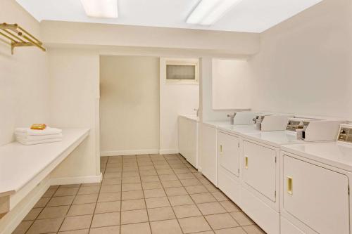 a kitchen with white counters and white cabinets at Travelodge by Wyndham Rapid City in Rapid City