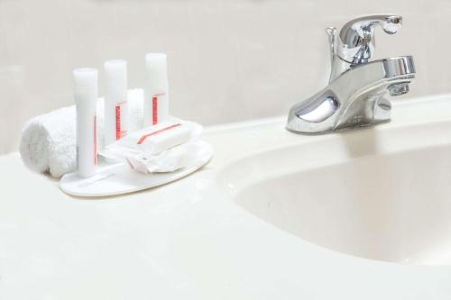 a bathroom sink with a toothbrush holder next to a faucet at Super 8 by Wyndham Willows in Willows