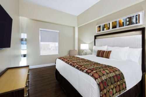 Habitación de hotel con cama grande y escritorio. en Hawthorn Suites by Wyndham McAllen en McAllen