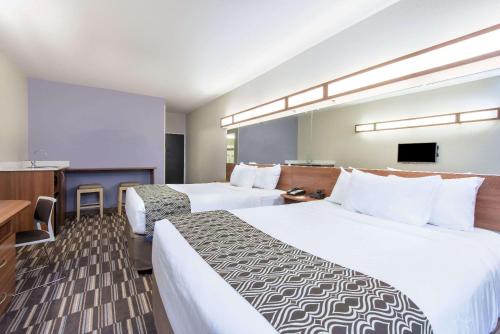Giường trong phòng chung tại Microtel Inn & Suites by Wyndham Cadiz