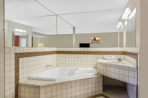 a bathroom with a tub and a sink at Travelodge by Wyndham Reno in Reno