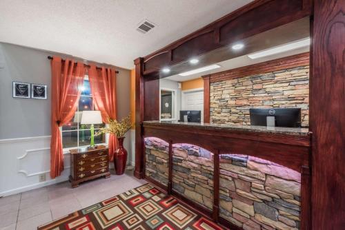 a bar in a room with a stone wall at Super 8 by Wyndham Alexander City in Alexander City