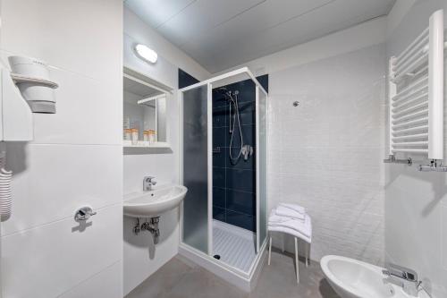 La salle de bains blanche est pourvue d'un lavabo et d'une douche. dans l'établissement The RomeHello, à Rome