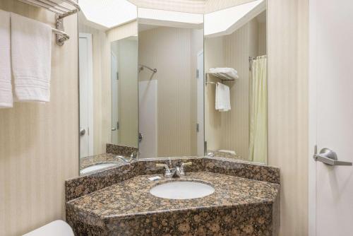 a bathroom with a sink and a mirror at Super 8 by Wyndham Harrisburg Hershey North in Harrisburg