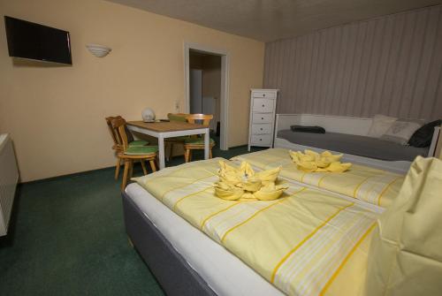 a bedroom with two beds with yellow flowers on them at Pension Immergrün in Kurort Jonsdorf