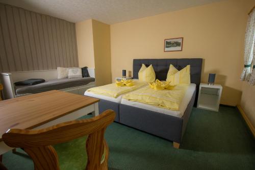 a hotel room with a bed and a couch at Pension Immergrün in Kurort Jonsdorf