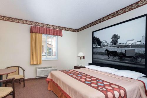 una habitación de hotel con un gran dibujo de un carruaje de caballos en Super 8 by Wyndham Harrisburg Hershey North en Harrisburg