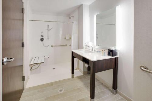 a white bathroom with a sink and a shower at Wingate by Wyndham San Angelo in San Angelo