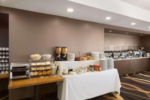a bakery with white tables and plates on it at Travelodge by Wyndham Niagara Falls Fallsview in Niagara Falls
