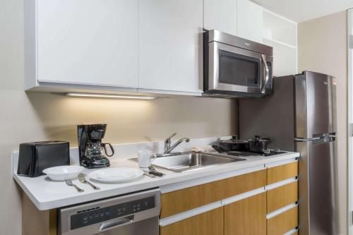 a kitchen with a sink and a microwave at Hawthorn Suites by Wyndham Wheeling at The Highlands in Triadelphia