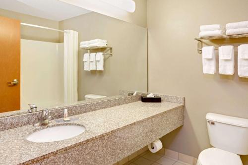 a bathroom with a sink and a toilet and a mirror at Super 8 by Wyndham South Bend in South Bend