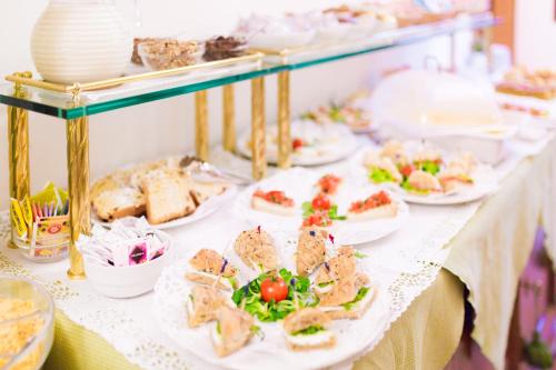 a buffet with plates of food on a table at Hotel Serenissima in Venice
