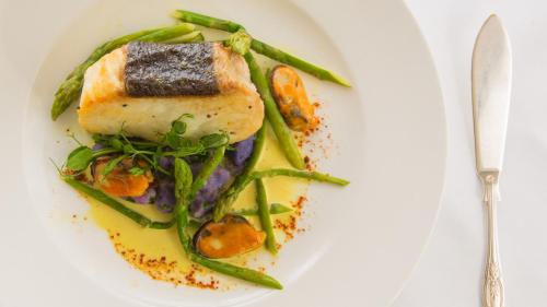 a plate of food with a piece of fish and asparagus at Priory Wareham in Wareham
