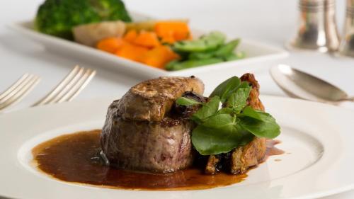 a plate of food with a piece of meat and gravy at Priory Wareham in Wareham