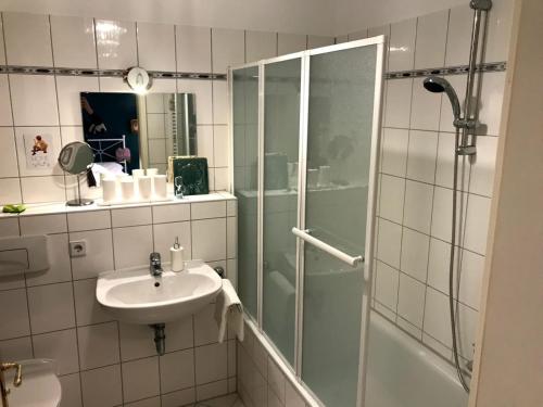 a bathroom with a glass shower and a sink at LE-Style! Leipzig Zentrum in Leipzig