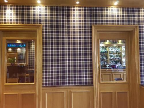 two doors in a room with black tiles on a wall at Ardshiel Hotel in Campbeltown